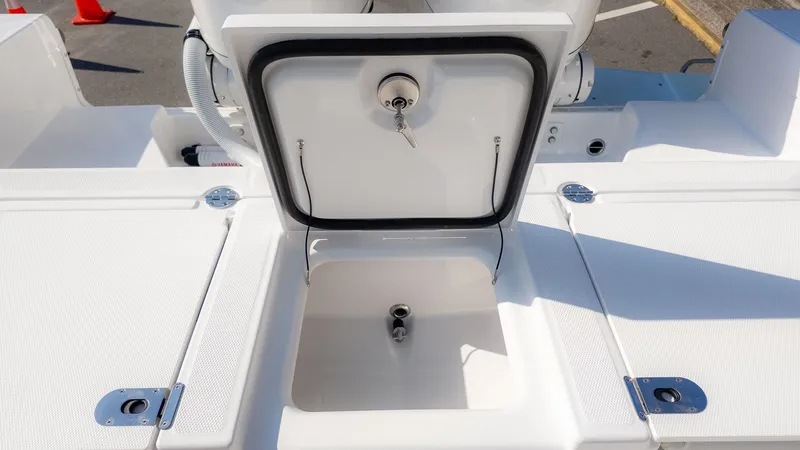 Slide: The Image of An open storage compartment on a boat with a white deck and metal fittings. - 12