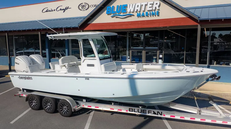 The Image of An Everglades 273 Center Console boat on a trailer in front of a marine store. - 1
