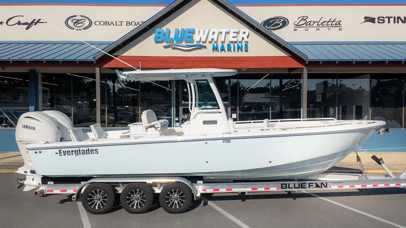 Slide: The Image of A 2027 Everglades 273 Center Console boat on a trailer in front of a boat dealership. - 28
