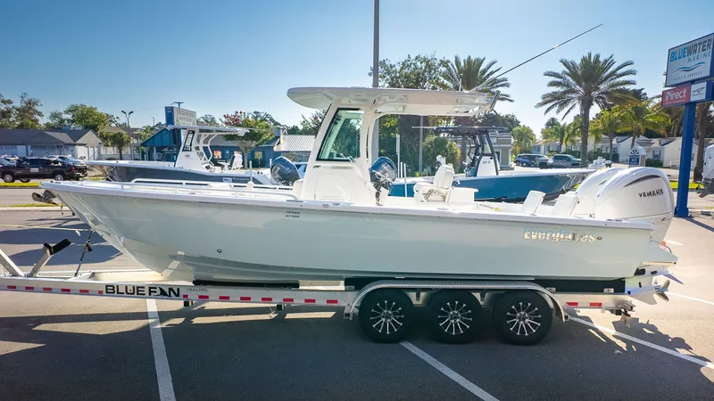 The Image of A 2027 Everglades 273 Center Console boat on a trailer in a sunny parking lot. - 1