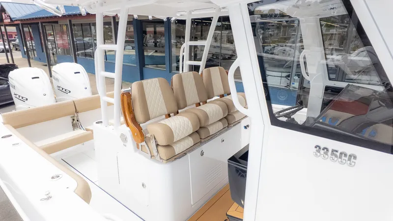 Slide: The Image of The image shows an Everglades 335 Center Console boat with beige seating and two outboard engines. - 7