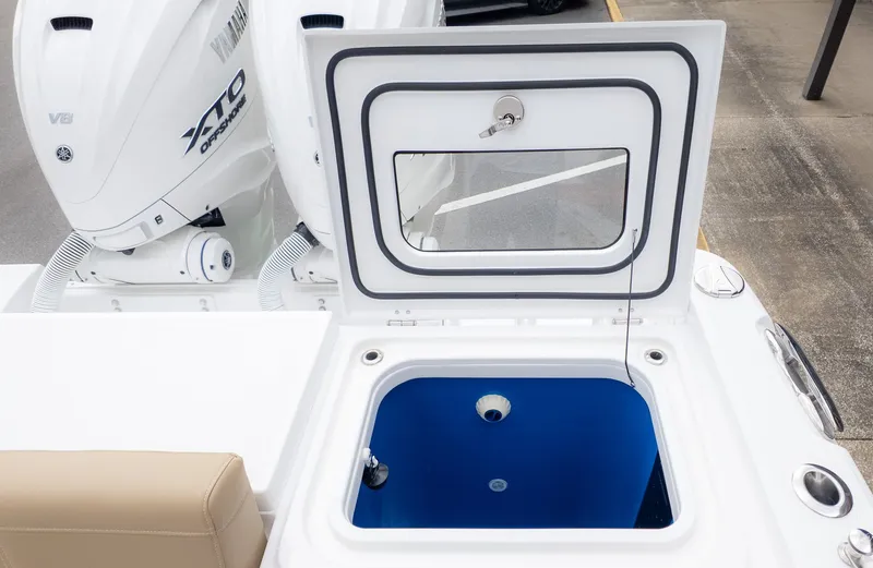 Slide: The Image of An open storage compartment on an Everglades 335 Center Console boat, featuring a blue interior. - 9