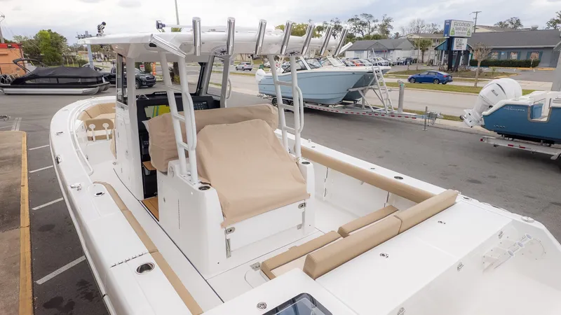Slide: The Image of A modern center console boat with cushions and rod holders, parked in a lot. - 30
