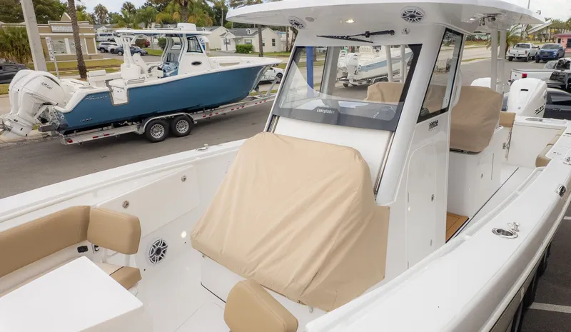 Slide: The Image of A modern boat with a white hull and beige seat covers, parked on a trailer. - 30
