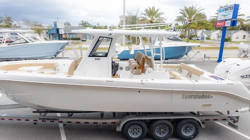 Slide: The Image of 2026 Everglades 335 Center Console on a trailer, parked with other boats nearby. - 3