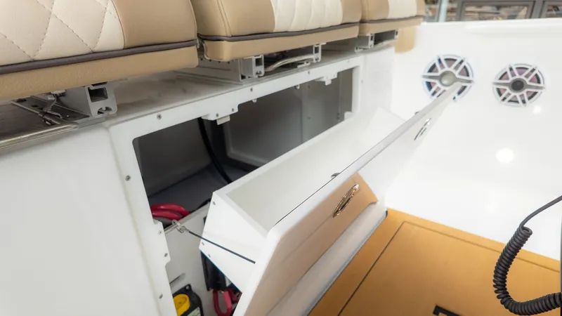 Slide: The Image of An open storage compartment on a boat with speakers and cushioned seats. - 27