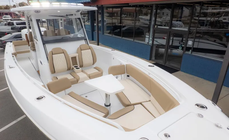The Image of The image shows a 2026 Everglades 335 Center Console boat with sleek seating and a table. - 1