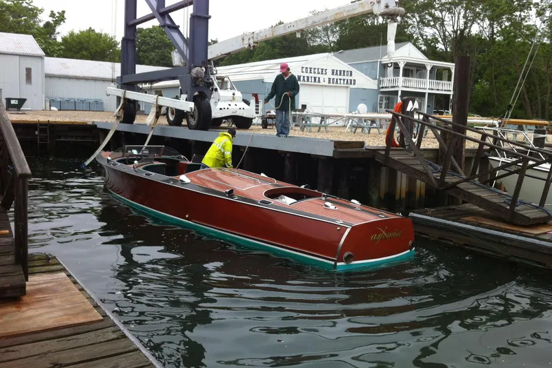 Slide: The Image of 1996 Hacker-Craft Triple Cockpit Runabout at dock, featuring classic wooden design and elegant finish. - 18