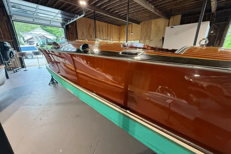 Slide: The Image of 1996 Hacker-Craft Triple Cockpit Runabout in a garage, showcasing polished wood finish. - 4