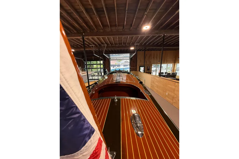 Slide: The Image of 1996 Hacker-Craft Triple Cockpit Runabout in a wooden boathouse, showcasing classic design. - 5