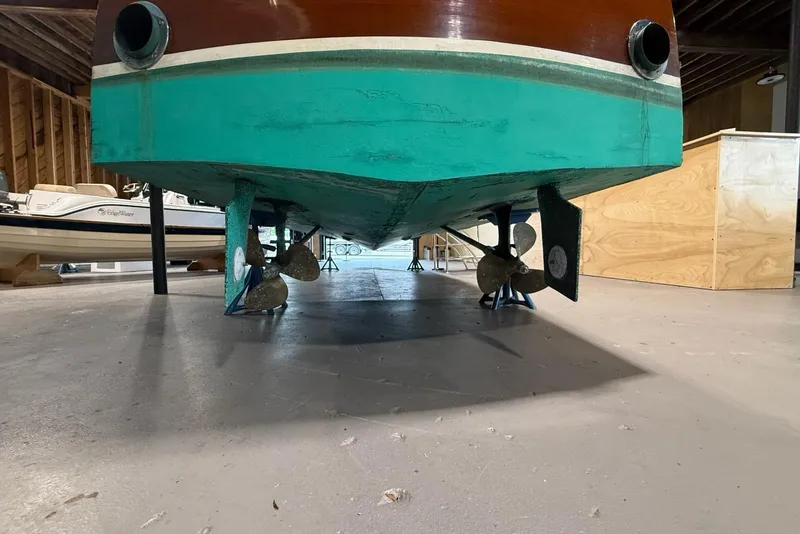 Slide: The Image of 1996 Hacker-Craft Triple Cockpit Runabout in storage, showcasing its propellers and rudder. - 17