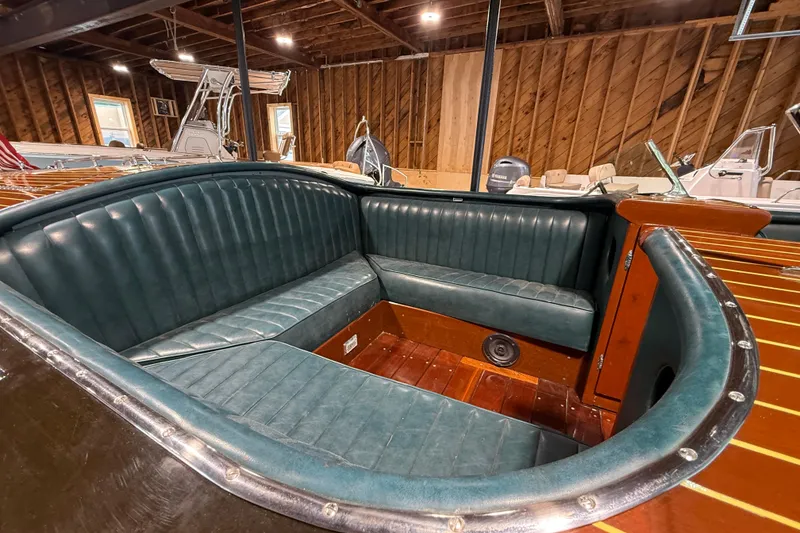 Slide: The Image of 1996 Hacker-Craft Triple Cockpit Runabout with green leather seating in a wooden interior. - 13