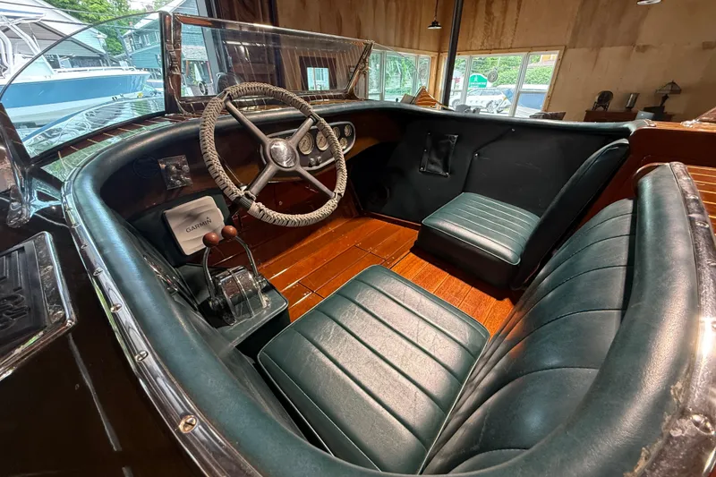 Slide: The Image of Interior of a 1996 Hacker-Craft Triple Cockpit Runabout with vintage steering and leather seats. - 10