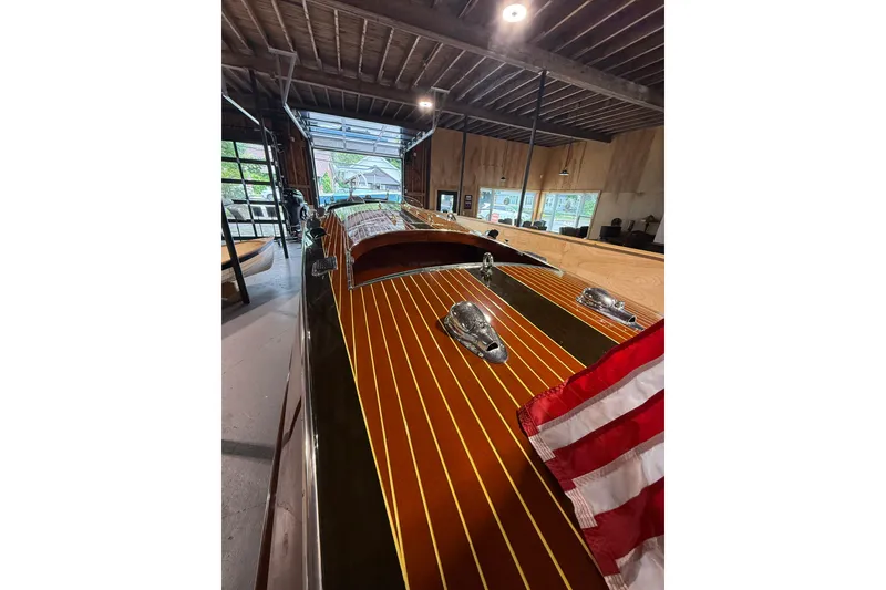 Slide: The Image of 1996 Hacker-Craft Triple Cockpit Runabout in a wooden garage, showcasing classic design and craftsmanship. - 7
