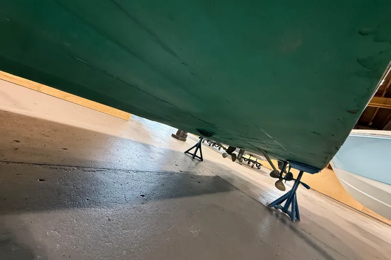 Slide: The Image of Underneath view of a 1996 Hacker-Craft Triple Cockpit Runabout on stands in a garage. - 9