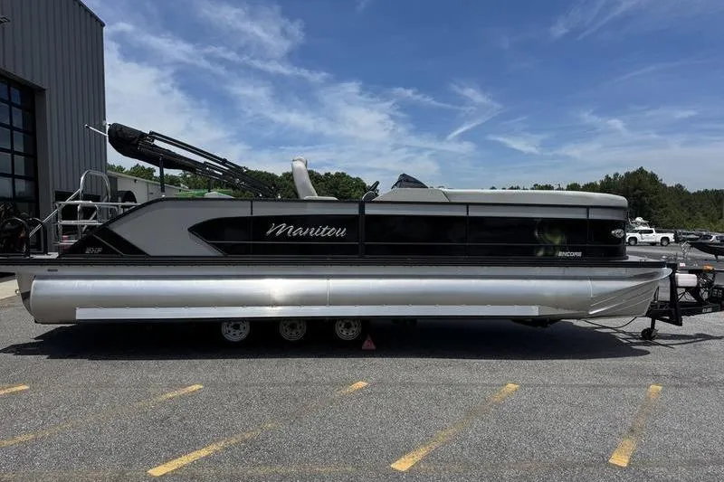 The Image of 2026 Manitou Encore 25 SL SHP pontoon boat parked outdoors on a sunny day. - 1