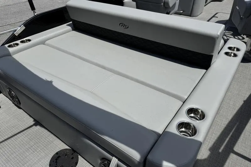 Slide: The Image of 2026 Manitou Encore 25 SL SHP boat seating area with cup holders and sleek design. - 19