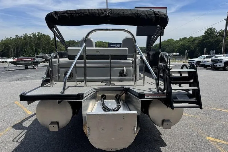 Slide: The Image of 2026 Manitou Encore 25 SL SHP pontoon boat, rear view, parked outdoors. - 5