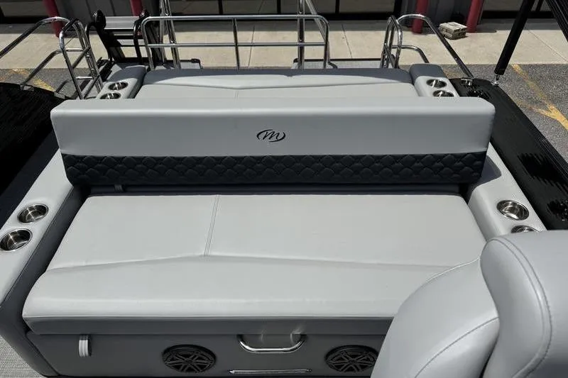 Slide: The Image of 2026 Manitou Encore 25 SL SHP boat interior with gray seating and cup holders. - 18