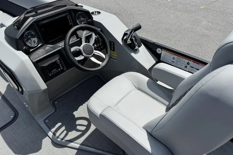 Slide: The Image of 2026 Manitou Encore 25 SL SHP boat cockpit with steering wheel and controls. - 12