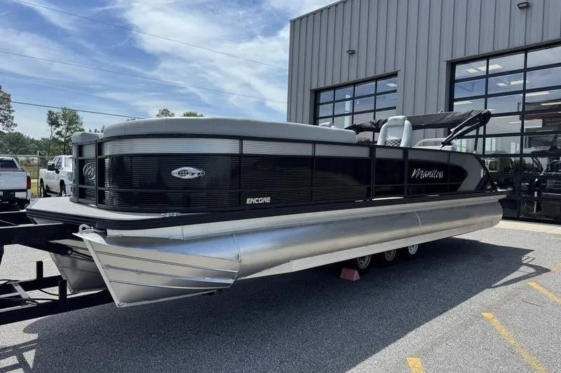 Slide: The Image of 2026 Manitou Encore 25 SL SHP pontoon boat parked outside a building. - 7
