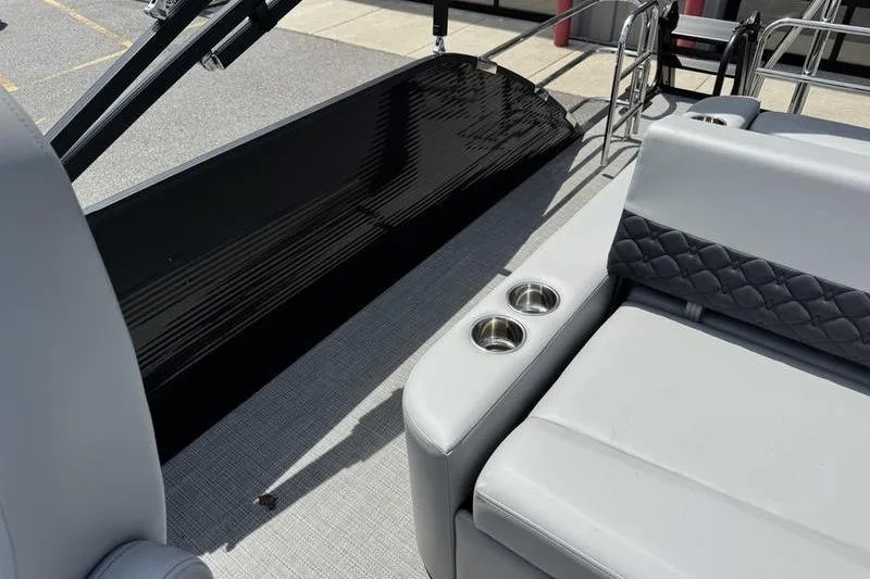 Slide: The Image of 2026 Manitou Encore 25 SL SHP boat interior with gray seating and cup holders. - 20