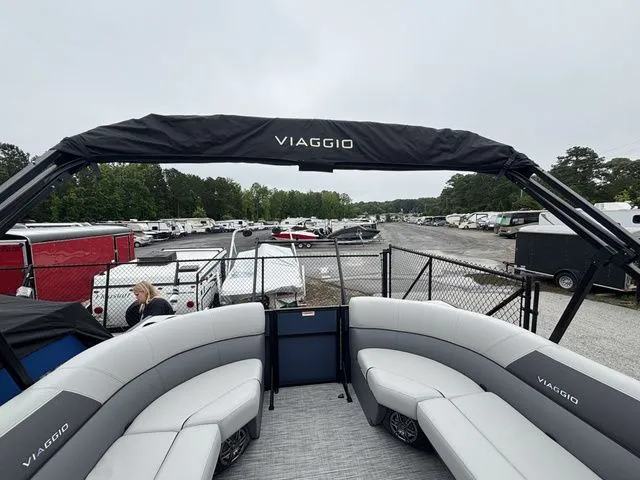 Slide: The Image of The Viaggio Lago V22U is a modern pontoon boat with gray seating and a black sunshade. - 18