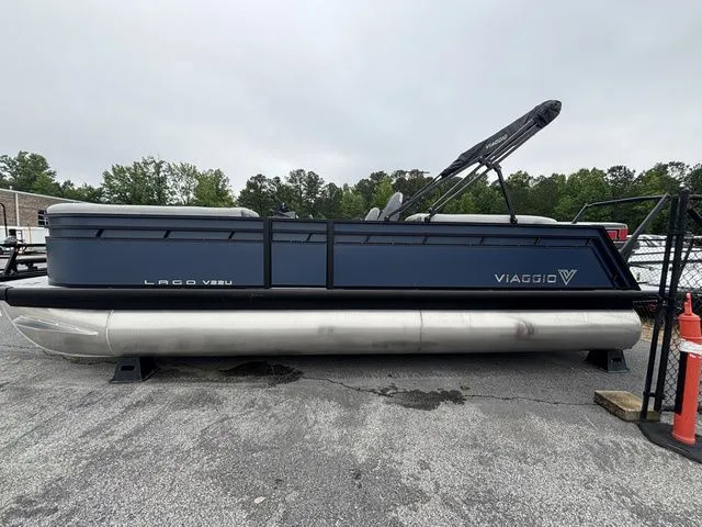 The Image of A Viaggio Lago V22U pontoon boat is parked on a lot. It features a blue hull. - 1