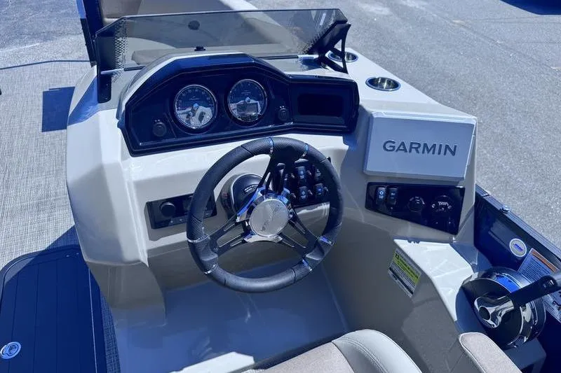 Slide: The Image of 2027 Manitou Aurora 23 RF SHP boat dashboard with Garmin navigation system and steering wheel. - 34