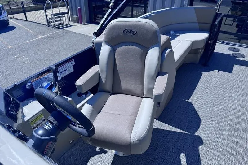 Slide: The Image of 2027 Manitou Aurora 23 RF SHP boat interior with captain's chair and steering wheel. - 30