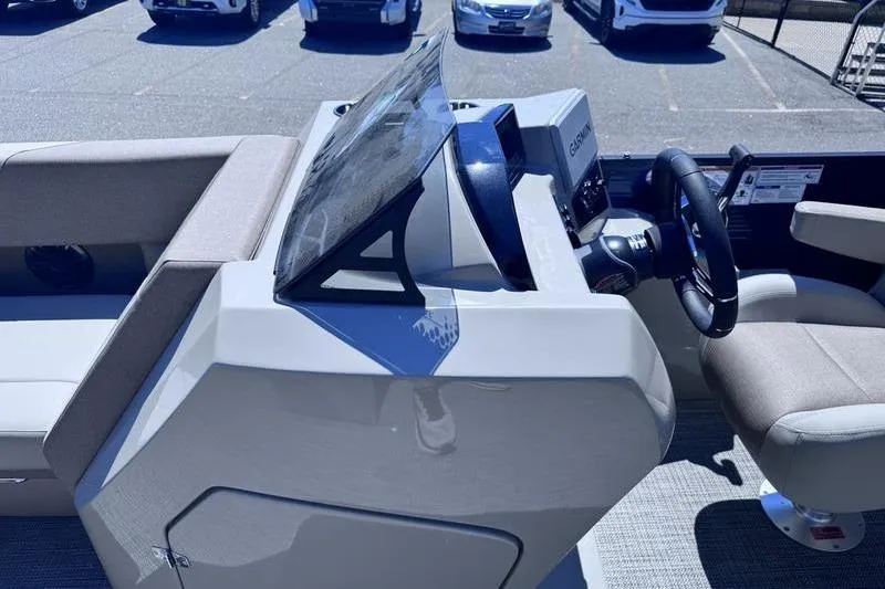 Slide: The Image of 2027 Manitou Aurora 23 RF SHP boat dashboard with steering wheel and seating. - 21