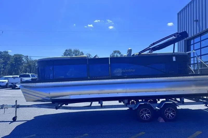 Slide: The Image of 2027 Manitou Aurora 23 RF SHP pontoon boat on a trailer in a parking lot. - 9