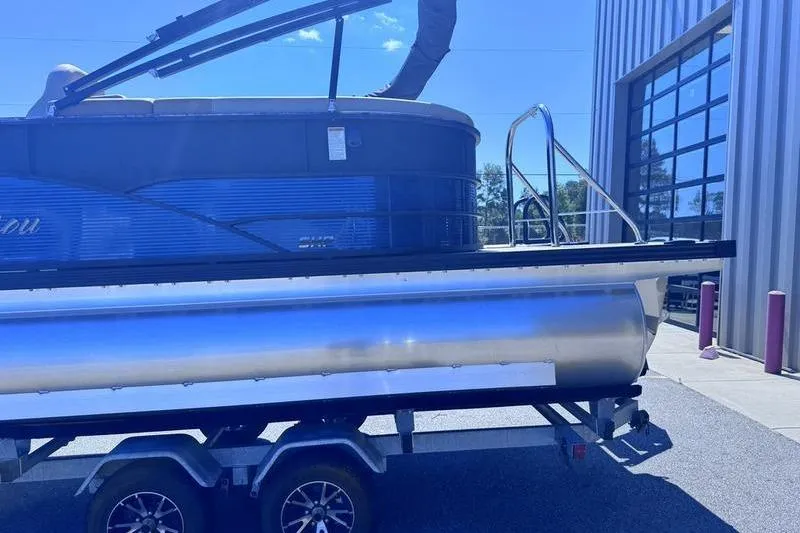 Slide: The Image of 2027 Manitou Aurora 23 RF SHP pontoon boat on trailer outside a building. - 14