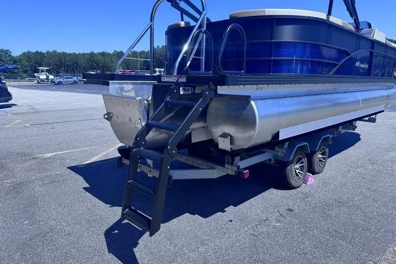 Slide: The Image of 2027 Manitou Aurora 23 RF SHP pontoon boat on trailer in parking lot. - 10