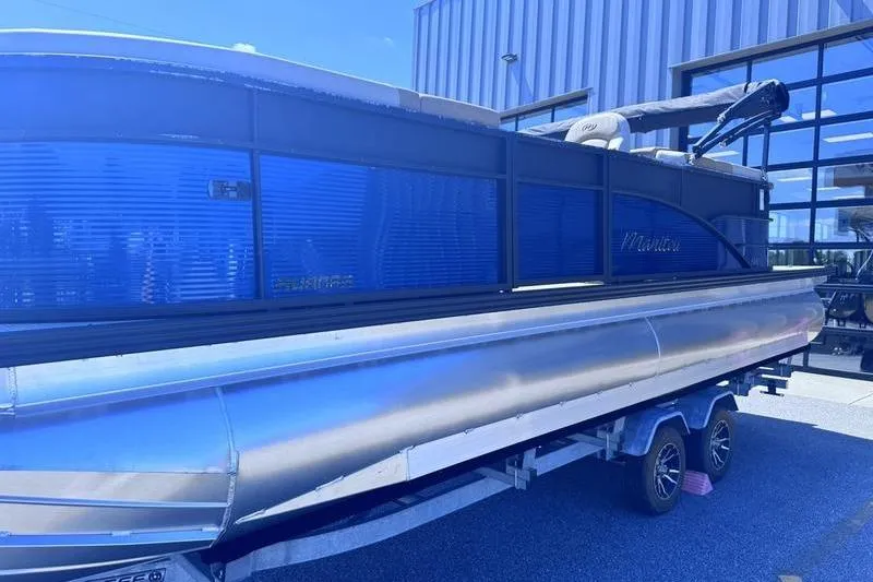 Slide: The Image of 2027 Manitou Aurora 23 RF SHP pontoon boat on trailer, parked outdoors. - 17