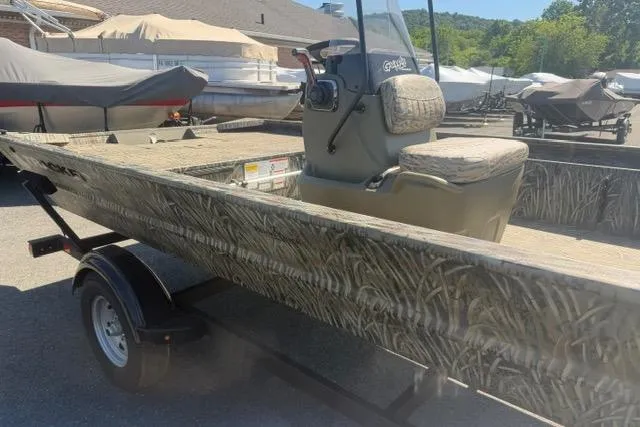 Slide: The Image of 2026 Tracker Grizzly 1860 CC boat on trailer, featuring camouflage design. - 2