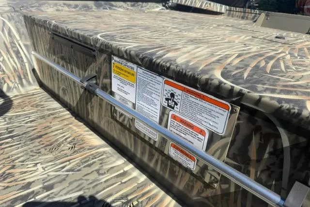 Slide: The Image of 2026 Tracker Grizzly 1860 CC boat with camouflage design and safety labels. - 5