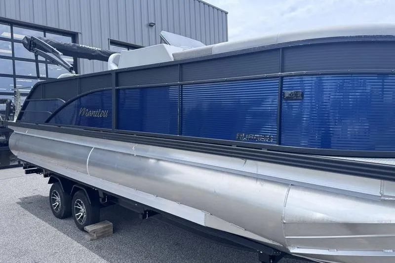 Slide: The Image of 2027 Manitou Aurora 23 SL SHP pontoon boat on trailer, blue and silver design. - 7