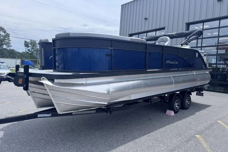 Slide: The Image of 2027 Manitou Aurora 23 SL SHP pontoon boat on trailer, parked outside a building. - 4