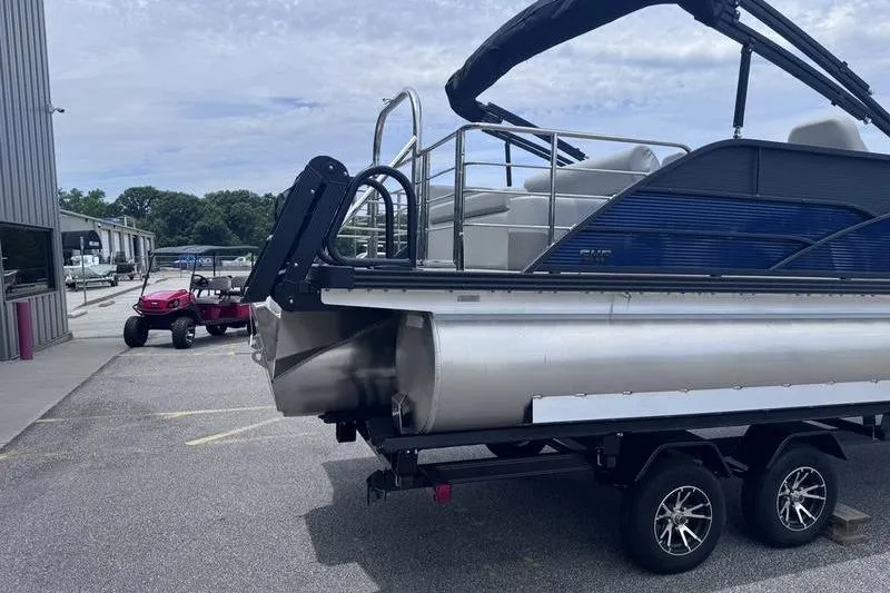 Slide: The Image of 2027 Manitou Aurora 23 SL SHP pontoon boat on trailer, parked outdoors. - 20