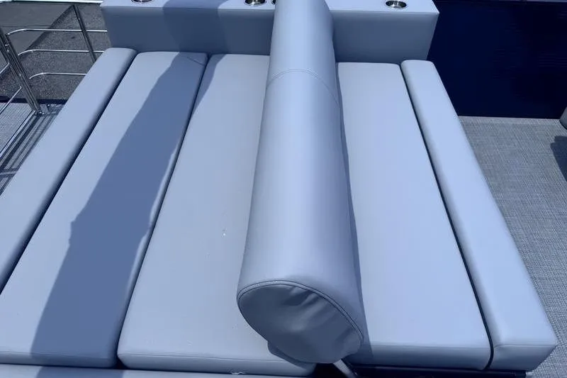 Slide: The Image of 2027 Manitou Aurora 23 SL SHP boat seating with light gray upholstery. - 24