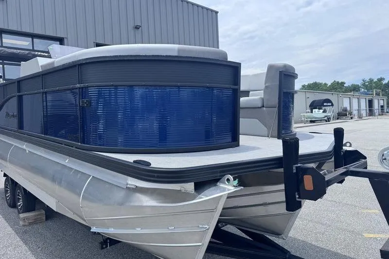 Slide: The Image of 2027 Manitou Aurora 23 SL SHP pontoon boat on trailer, parked outdoors. - 5