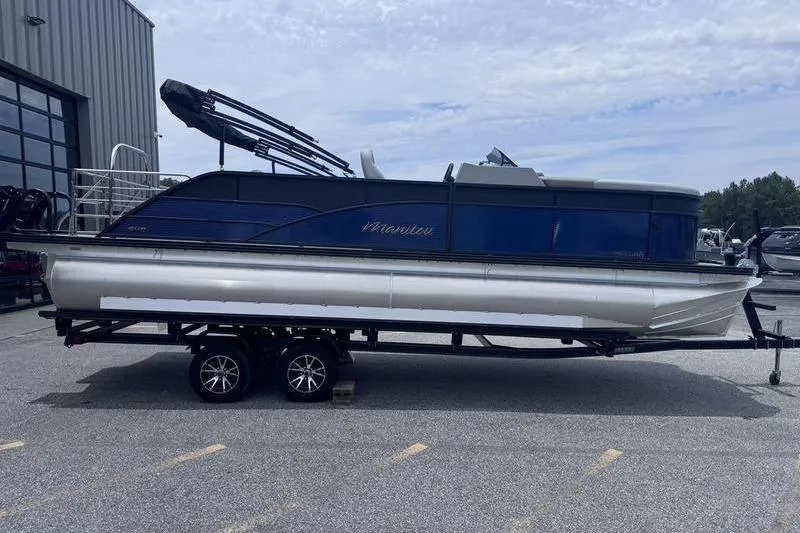 Slide: The Image of 2027 Manitou Aurora 23 SL SHP pontoon boat on trailer, parked outdoors. - 8