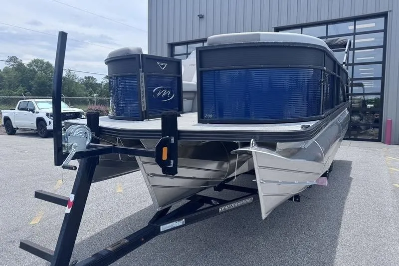 Slide: The Image of 2027 Manitou Aurora 23 SL SHP pontoon boat on trailer, parked outdoors. - 6