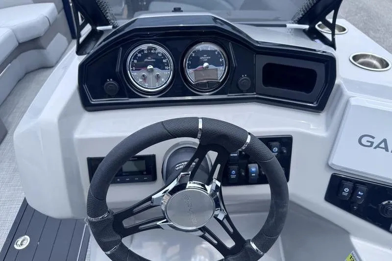 Slide: The Image of Steering console of 2027 Manitou Aurora 23 SL SHP boat with gauges and controls. - 17
