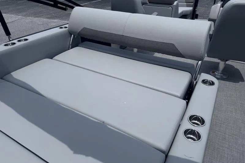 Slide: The Image of 2027 Manitou Aurora 23 SL SHP boat interior with gray cushioned seating and cup holders. - 26