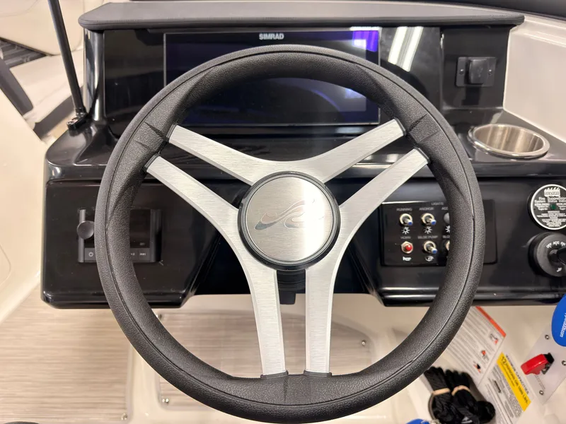 Slide: The Image of The image shows the helm of a Sea Ray SPX 210 boat with modern controls. - 35
