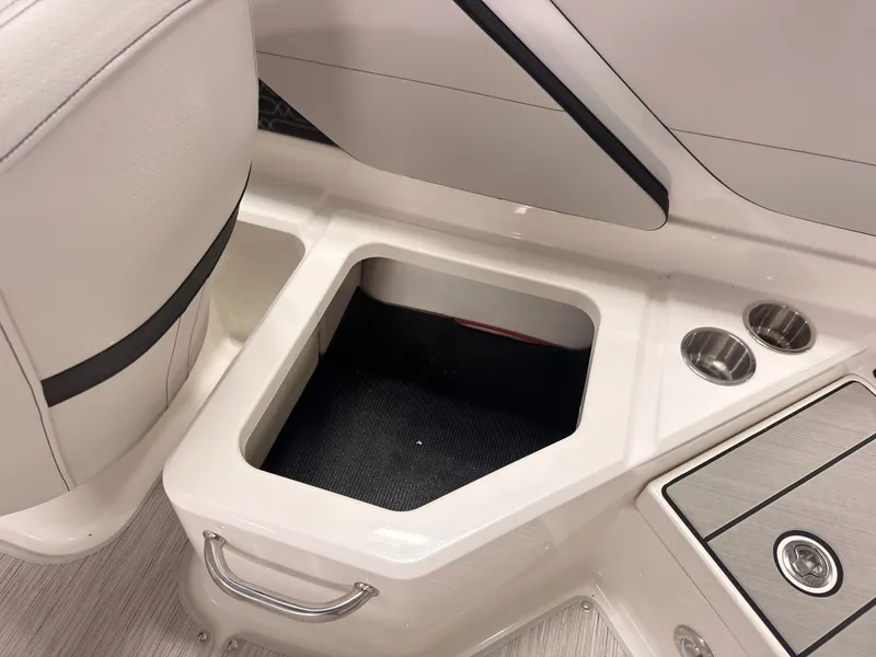 Slide: The Image of An open storage compartment on a Sea Ray SPX 210 boat with cup holders beside it. - 19