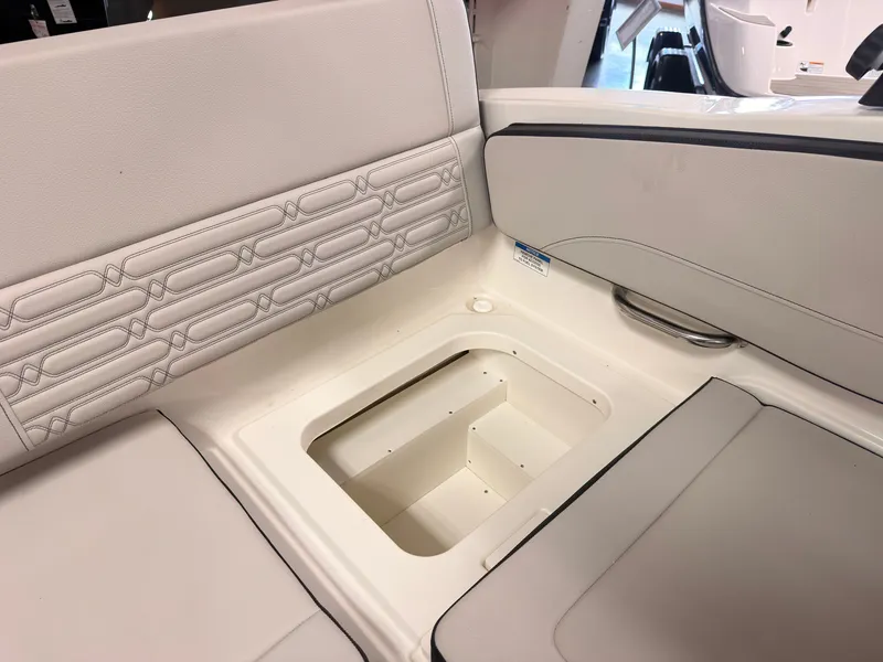 Slide: The Image of The image shows the interior of a Sea Ray SPX 210 boat with beige upholstery and storage space. - 14