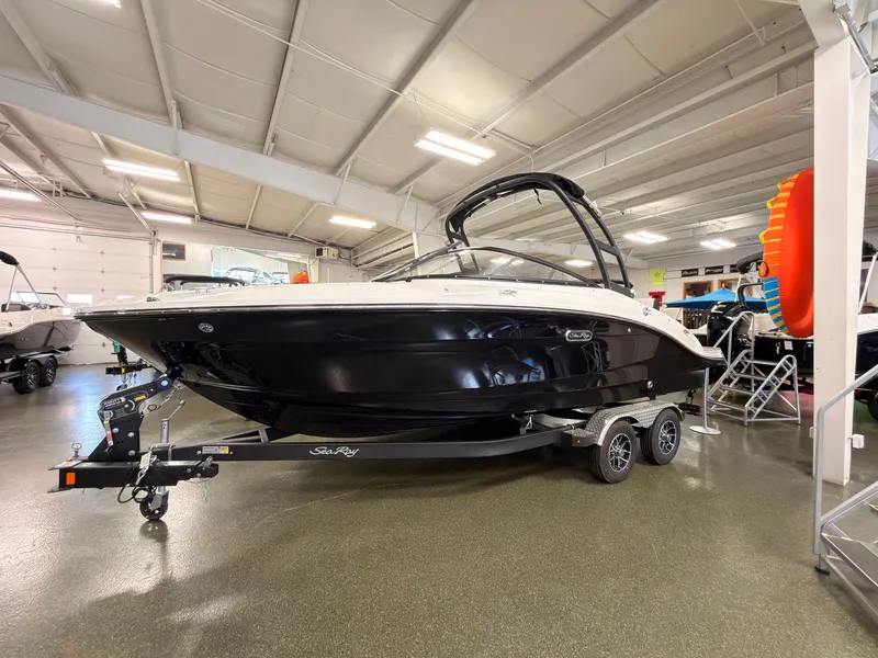 The Image of A 2026 Sea Ray SPX 210 boat on a trailer in a showroom. - 0